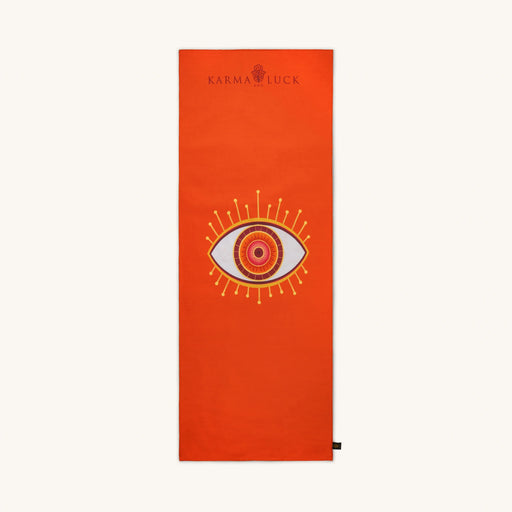 Orange yoga mat with eye design and Karma Luck logo on a white background